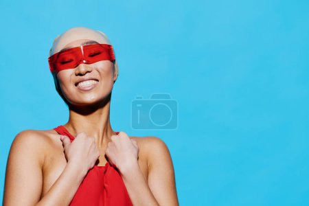 Foto de Mujer pelo rojo bastante lindo sonriente retrato modelo positivo expresión traje de baño moda gafas cara asiático azul elegancia belleza moda cuerpo gafas de sol verano emoción - Imagen libre de derechos