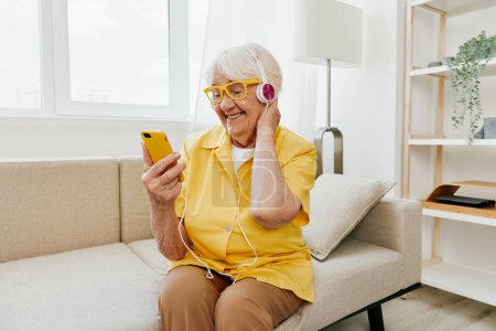 Foto de Mujer de edad avanzada feliz que mira en la sonrisa de la videollamada del teléfono, tecnología para la comunicación, interior moderno brillante, estilo de vida comunicación en línea. Foto de alta calidad - Imagen libre de derechos