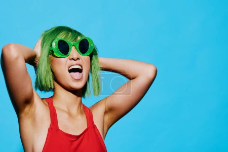 Foto de Mujer sonrisa atractivo cabello wow cara blanco gafas de sol expresión impactado peluca belleza verde mano retro rojo retrato verano traje de baño moda moda negro azul - Imagen libre de derechos