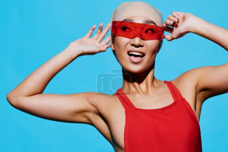 Foto de Emoción mujer belleza un modelo atractivo gafas asiático moda glamour rojo expresión azul estilo retrato sonriente gafas de sol persona joven elegancia positiva bonita - Imagen libre de derechos