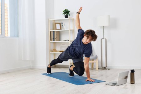 Photo for Man house healthy floor exercise training gym online activity indoor exercising young room adult sport health muscle fitness mat home lifestyle - Royalty Free Image