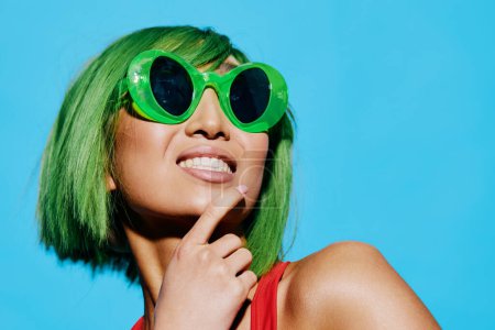 Foto de Mujer mujer retrato emoción sonrisa verde elegante divertido peluca verano sorprendido mano joven moda pelo rojo traje de baño gafas de sol belleza de moda - Imagen libre de derechos