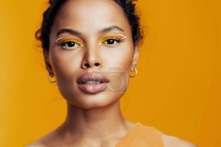 Téléchargez les photos : Femme africaine sourire portrait maquillage studio oeil modèle coloré peau rose visage noir cosmétique copie cosmétologie ethnique jaune beauté style créatif bel espace - en image libre de droit