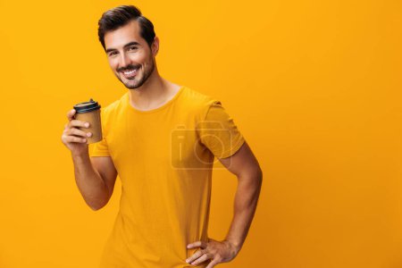 Téléchargez les photos : Énergie homme isolé sourire café papier rose t-shirt sommeil mode thé studio tasse étudiant chaud tasse hipster copie espace boisson heureuse - en image libre de droit
