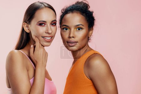 Photo for Face woman colorful girls eye healthy pink two make-up shine race model portrait mixed american attractive care together happy african studio bodycare beauty skin beautiful - Royalty Free Image