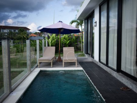 Foto de Villa moderna en Bali con piscina y tumbonas con vistas a los campos de arroz al aire libre. Foto de alta calidad - Imagen libre de derechos