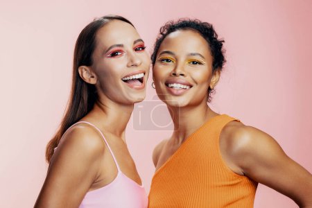 Photo for Woman colorful shine happy together model mixed healthy skin studio girls care pink eye beautiful race bodycare face american beauty caucasian make-up african attractive portrait two - Royalty Free Image