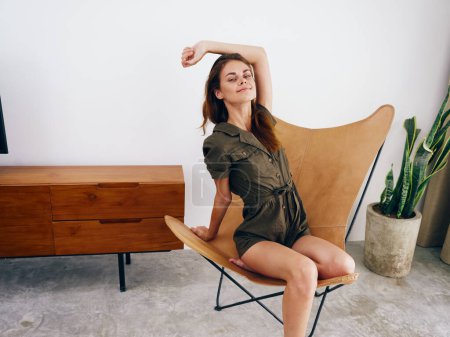 Foto de Modelo de mujer se sienta en una silla en casa sonrisa, diversión y relajación, moderno estilo de vida escáner interior con estilo, espacio de copia. Foto de alta calidad - Imagen libre de derechos