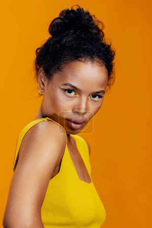 Téléchargez les photos : Beauté femme africaine rose studio ethnique espace sourire coloré jaune beau style mode noir peau cosmétique créatif copie modèle portrait maquillage visage cosmétologie - en image libre de droit
