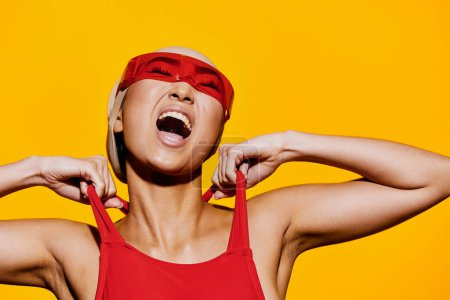 Téléchargez les photos : Portrait femme rouge plage asiatique studio lunettes jaune maillot de bain mignon beauté modèle jeune gai bleu mode amusement émotion blanc sourire lunettes de soleil heureux personne un - en image libre de droit