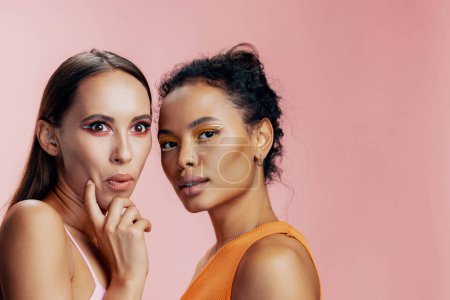 Photo for Woman portrait face american pink shine race make-up beautiful studio girls two beauty model healthy happy eye together skin attractive bodycare mixed african care colorful - Royalty Free Image