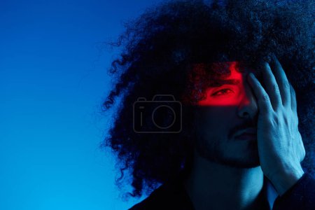 Photo for Fashion portrait of a man with curly hair on a blue background, multinational, colored light, trendy, modern concept. High quality photo - Royalty Free Image