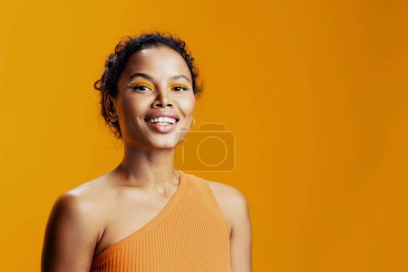 Téléchargez les photos : Femme copie coloré visage style oeil studio de mode sourire bel espace ethnique beauté peau créative cosmétique rose heureux portrait maquillage noir modèle jaune afrique cosmétologie - en image libre de droit