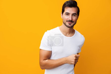 Téléchargez les photos : Copier homme casual blanc casual vêtements jaune fond style de vie sourire modèle vue de face t-shirt blanc jeans studio espace portrait chemise maquette vêtements isolés - en image libre de droit
