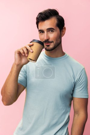 Téléchargez les photos : Mode homme t-shirt rose copie chaud étudiant studio espace café heureux sourire tasse thé hipster boisson sommeil papier énergie - en image libre de droit