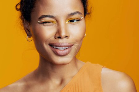 Téléchargez les photos : Femme mode cosmétique créatif studio peau beauté africaine sourire maquillage style visage espace heureux beau noir ethnique oeil rose modèle jaune coloré cosmétologie portrait copie - en image libre de droit