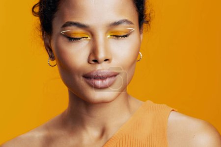 Téléchargez les photos : Sourire femme beauté mannequin coloré portrait cosmétologie studio peau beau maquillage jaune noir cosmétique africain style créatif visage - en image libre de droit