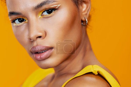 Foto de Modelo de moda estilo mujer piel africana maquillaje amarillo estudio cosmetología cara creativa negro retrato cosmética colorida belleza hermosa sonrisa - Imagen libre de derechos