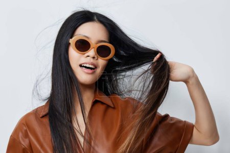 Foto de Mujer asiática gafas de sol beige retrato cara hermoso estilo de vida modelo glamour feminidad cosmética belleza atractivo vacaciones salón viaje moda cabello - Imagen libre de derechos