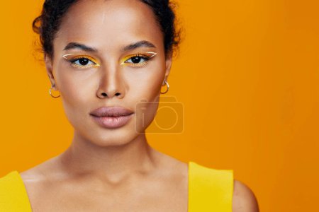 Téléchargez les photos : Sourire femme style africain cosmétique peau espace beauté mode copie noir modèle maquillage beau rose créatif cosmétologie visage portrait jaune coloré studio - en image libre de droit