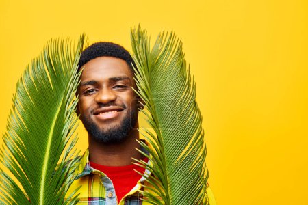 Foto de Hombre expresión persona moda negro feliz palma multinacional americano árbol piel elegante amarillo modelo africano masculino divertido tropical sonriente freelancer etnia estilo de vida humor - Imagen libre de derechos