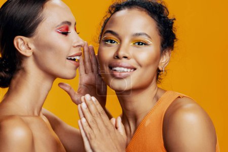 Photo for Woman girl beautiful together studio caucasian healthy care shine beauty make-up attractive bodycare colorful american african skin portrait happy face mixed race model two eye yellow - Royalty Free Image