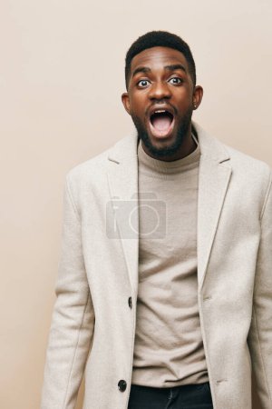 Téléchargez les photos : Expression homme beige émotion africaine heureux coloré isolé portrait jeune lunettes confiant mode un gris personne fond noir afro-américain américain gars visage - en image libre de droit