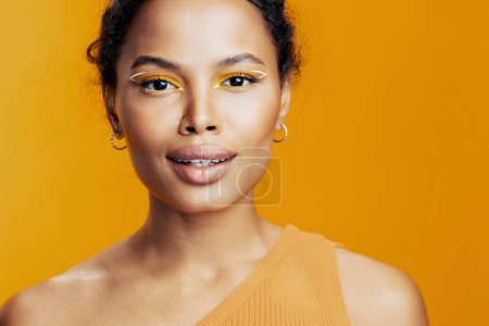 Téléchargez les photos : Femme cosmétologie modèle créatif cosmétique peau style studio mode noir sourire beauté visage maquillage coloré beau jaune africain portrait - en image libre de droit