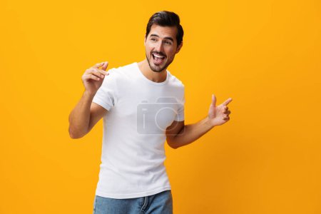 Téléchargez les photos : Homme mannequin fond modèle jeans copier vêtements vêtements sourire gai t-shirt casual espace blanc jaune mode portrait design studio modèle blanc avant chemise vue style de vie casual isolé - en image libre de droit