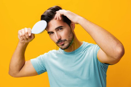 Photo for Hair man background lifestyle face handsome looking yellow comb close-up hairbrush portrait holding background studio loss hairstyle beauty hair beard brushing care barber combing smiling - Royalty Free Image