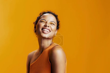 Foto de Belleza mujer sonrisa estilo amarillo africano negro hermosa piel retrato estudio moda cosmética colorido creativo cosmetología cara modelo maquillaje - Imagen libre de derechos