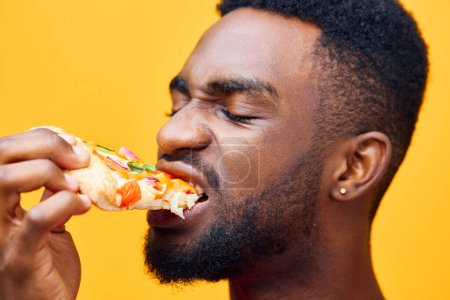 Photo for Man space yellow copy afro isolated food enjoy weight pizza delivery lifestyle fast eat person food smile happy hold guy nutrition online black background - Royalty Free Image