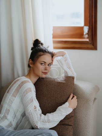 Photo for Woman in sweater and home pants relaxing lying on the couch at home, cozy day off in comfort, real lifestyle with a smile. High quality photo - Royalty Free Image