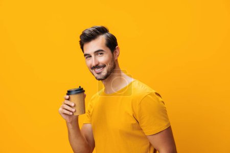 Téléchargez les photos : Homme hipster isolé sourire espace chaud rose tasse mode copie studio étudiant t-shirt thé heureux tasse papier dormir boire café énergie - en image libre de droit