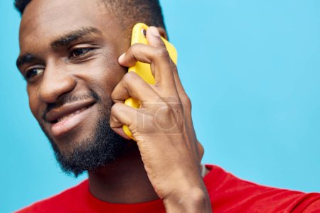 Foto de Móvil hombre estilo de vida fondo feliz tecnología africana mostrando teléfono retrato joven teléfono inteligente aislado negro teléfono celular modelo millennial emocionado persona sonrisa ciberespacio azul - Imagen libre de derechos