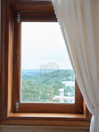 Téléchargez les photos : Vieille fenêtre avec cadre en bois et rideau lumineux dans le style traditionnel de la maison avec une belle vue. Photo de haute qualité - en image libre de droit