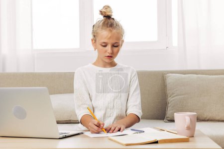 Photo for Studying laptop child girl school schoolgirl couch lesson computer lifestyle education homework online technology home distance learning teacher - Royalty Free Image