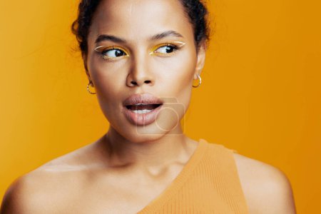 Foto de Cosmetología mujer moda creativa africana piel retrato negro belleza étnico estilo amarillo espacio sonrisa cara colorido estudio modelo ojo copia cosmética rosa maquillaje hermoso - Imagen libre de derechos