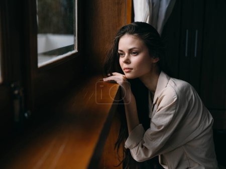 Photo for Portrait of young woman at home by window with wooden frame, autumn mood, cozy lifestyle, sleepy weather. High quality photo - Royalty Free Image
