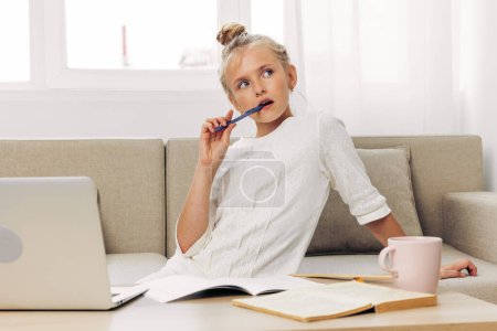 Photo for Laptop lifestyle education technology online girl homework school couch home studying schoolgirl smile pupil lesson happy learning young computer child teacher distance cyberspace - Royalty Free Image