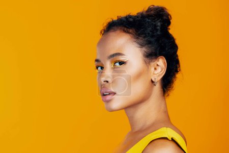Foto de Mujer hermosa negro estilo africano moda rosa modelo copia cara belleza estudio amarillo cosmetología cosmética espacio creativo étnico maquillaje retrato piel sonrisa colorido - Imagen libre de derechos