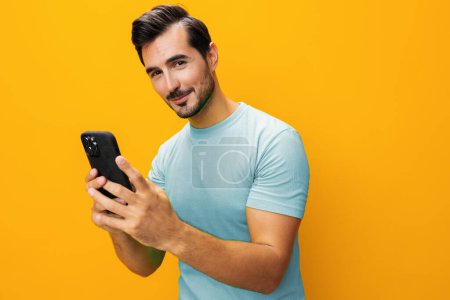 Photo for Happy man phone portrait smiling mobile eyeglass lifestyle copy smartphone yellow technology surprise message communication phone pointing studio business cyberspace space - Royalty Free Image