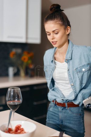Foto de Mujer sensual y de moda disfrutando de una copa de vino tinto en casa, cabello rizado y belleza elegante - Imagen libre de derechos