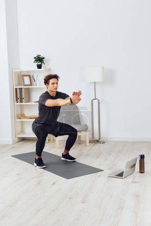 Photo for Man indoor male room house strong exercising abs exercise fitness home strength sport health young lifestyle gym watch activity training healthy - Royalty Free Image