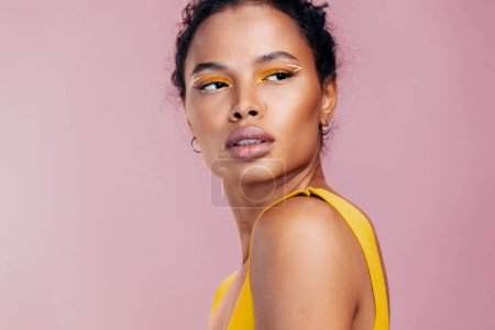 Foto de Mujer cosmética maquillaje creativo amarillo retrato piel sonrisa modelo cosmetología negro estilo moda belleza africano cara estudio colorido hermoso - Imagen libre de derechos