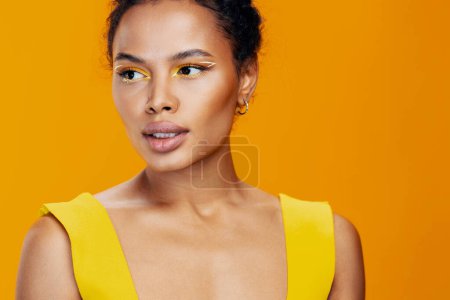 Téléchargez les photos : Femme peau noire belle créative africaine cosmétologie sourire studio cosmétique beauté modèle jaune maquillage visage portrait mode coloré - en image libre de droit