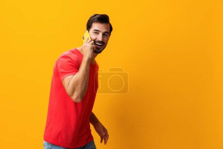 Foto de Hombre estilo de vida copiar teléfono retrato sorpresa teléfono negocio ciberespacio feliz espacio de comunicación móvil sonriente estudio amarillo tecnología apuntando mensaje gafas smartphone - Imagen libre de derechos