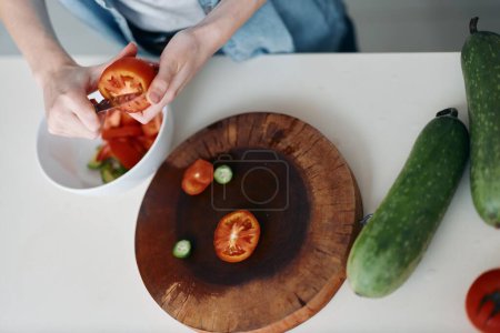 Téléchargez les photos : Salade de légumes frais dans un bol vert sur une assiette en bois, préparation saine de repas pour femmes dans une cuisine naturelle - en image libre de droit