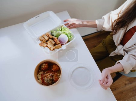 Téléchargez les photos : Nourriture de la livraison sur la table en ustensiles en plastique, un concept de restauration rapide. Photo de haute qualité - en image libre de droit