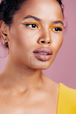 Téléchargez les photos : Rose femme cosmétologie peau visage coloré maquillage cosmétique espace portrait heureux noir ethnique africain studio style jaune oeil créatif copie sourire mode beauté beau modèle - en image libre de droit